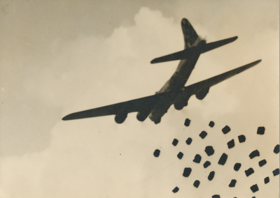 879257 Afbeelding van een Amerikaans B-17 vliegtuig boven de stad Utrecht dat voedselpakketten afwerpt in het kader van ...